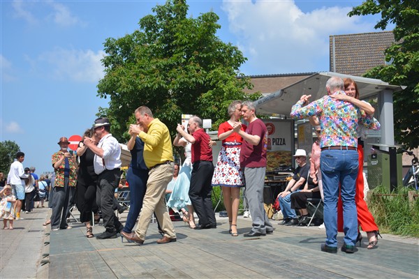 A group of people dancing on a street

Description automatically generated